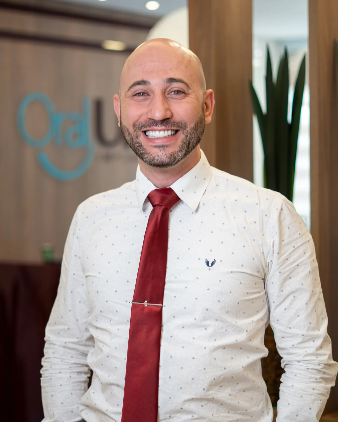 Dr. Lucas Quioca sorrindo na recepção da Oral Unic Vinhedo